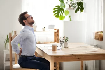 Man stretching back while sitting at table